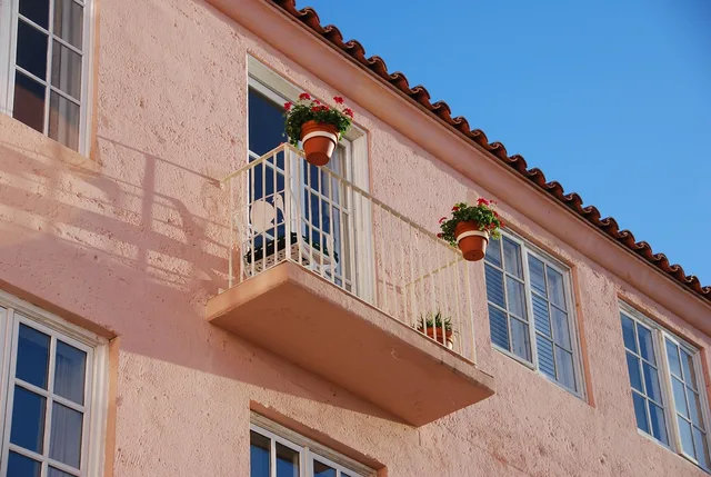 building exterior, stucco, flower boxes, building, exterior, structure, architecture, window, property, house, outdoor, residence, home, balcony, brown balcony, brown box, stucco, stucco, stucco, stucco, stucco, balcony. Phoenix vs Seattle exterior repaint costs, how climate changes coating choices